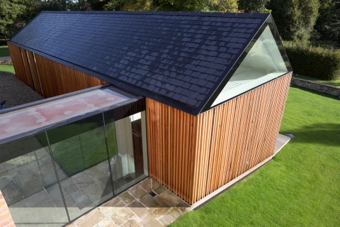 Maison contemporaine avec extension vitrée dans jardin paysager