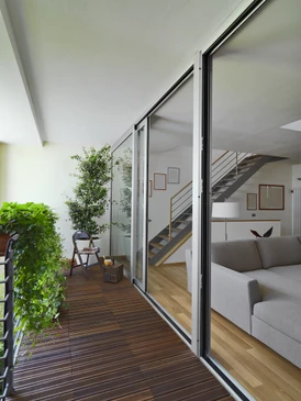 Intérieur résidentiel moderne avec salon ouvert donnant sur terrasse privée par baie vitrée coulissante
