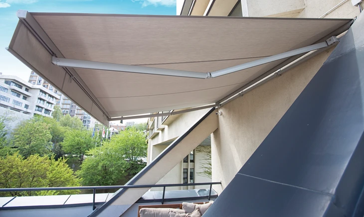 Un menuisier prenant les mesures d'une fenêtre ou d'un store extérieur sur la façade d'une maison, en utilisant ses outils de mesure professionnels (mètre, niveau), concentré sur le chantier. La photo doit être prise en extérieur naturel dans les Alpes-Maritimes, montrant clairement le professionnel en action engagé directement dans son travail sans intermédiaire, illustrant la présence personnelle du dirigeant du début à la fin du chantier.