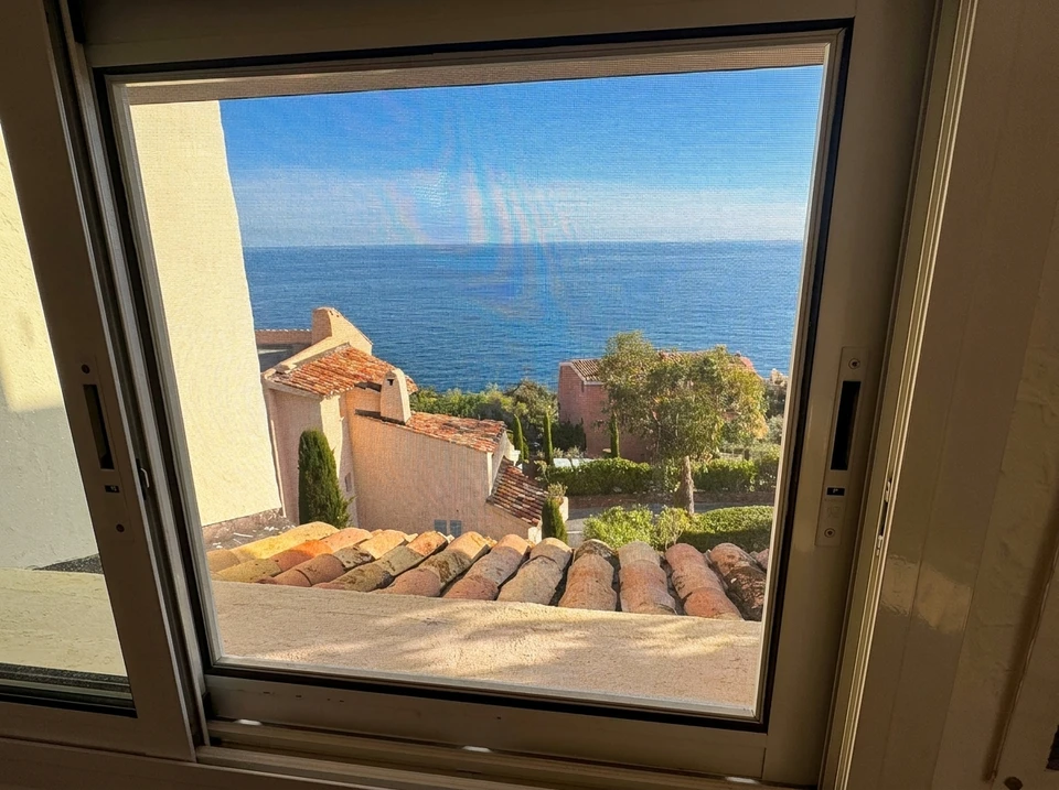 La main tient la poignée d'une fenêtre en plastique double vitrage, fermant et ouvrant la fenêtre avec un mécanisme rotatif, la position de la poignée pour la ventilation, la micro-ventilation